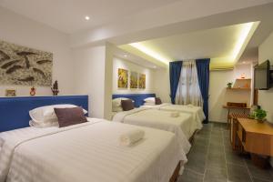 Habitación de hotel con 3 camas con sábanas blancas en Neth Socheata Hotel, en Siem Reap