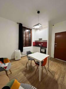 a living room with a table and chairs and a kitchen at T1 in Toulouse