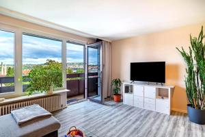 a living room with a flat screen tv and large windows at Ferienwohnung Goldstadtblick in Pforzheim