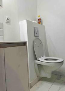 a bathroom with a white toilet in a white room at T1 in Toulouse