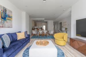 sala de estar con sofá azul y silla amarilla en Sun-kissed 3BR Loft with Patio Minutes to NYC, en Hoboken