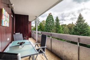 a balcony with a table and chairs and trees at Ferienwohnung Goldstadtblick in Pforzheim