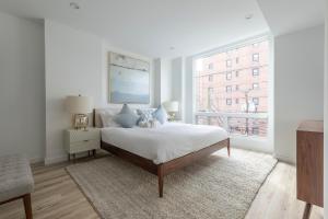 Habitación blanca con cama y ventana en Sun-kissed 3BR Loft with Patio Minutes to NYC, en Hoboken