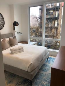 1 dormitorio con cama y ventana grande en Sun-kissed 3BR Loft with Patio Minutes to NYC, en Hoboken