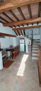 eine Küche und ein Esszimmer mit einem Tisch und einer Treppe in der Unterkunft Appartamento Vermentino-Agriturismo Salustri in Cinigiano