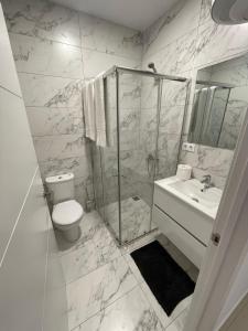 y baño con ducha, aseo y lavamanos. en Apartamentos La Meridian, en Barcelona