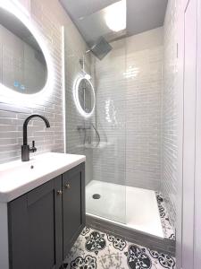 a bathroom with a shower and a sink and a tub at Pebbles Suiten by RiNG in Regensburg