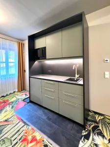 a kitchen with a sink and a counter top at Pebbles Suiten by RiNG in Regensburg