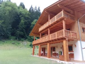 a large wooden house with a balcony on it at B&B Maso Ghirola in Pinzolo