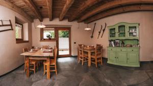 a dining room with a wooden table and chairs at B&B Maso Ghirola in Pinzolo