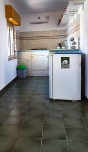een keuken met een witte koelkast en een tegelvloer bij CASA D'ALUNZIO - CASE PER FERIE IN OSPITALITA' DIFFUSA in San Marco dʼAlunzio