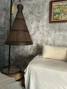 Un dormitorio con una cama con una lámpara al lado en Les lauriers rouge, en Peyriac-de-Mer