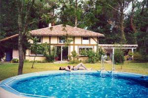 una mujer en el borde de una piscina en Les Villas de Messanges, en Messanges