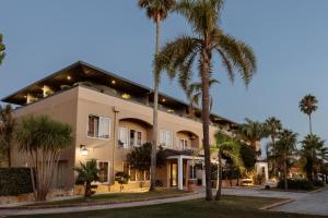 un edificio con palmeras delante en Quinta do Eden, en Vagos