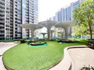 um parque com uma área relvada com edifícios em Arte Plus Ampang em Kuala Lumpur