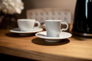 two white cups and saucers sitting on a table at Hotel Atari in Donostia-San Sebastián