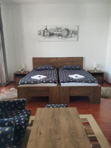 2 camas en una habitación con mesa y sillas en Panoráma apartman, en Pécs