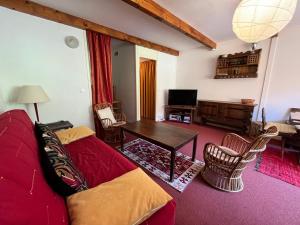 sala de estar con sofá rojo y mesa en Appartement Enchastrayes, 2 pièces, 6 personnes - FR-1-165A-26 en Enchastrayes