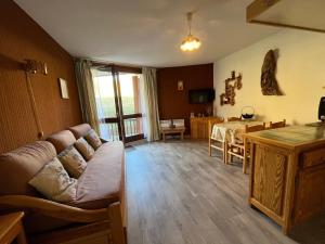 ein Wohnzimmer mit einem Sofa und einem Tisch in der Unterkunft Studio Enchastrayes, 1 pièce, 4 personnes - FR-1-165A-35 in Enchastrayes