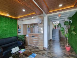 una hall con divano e parete verde di Hotel Harmony Blue Mcleodganj, Dharamshala a Dharamshala