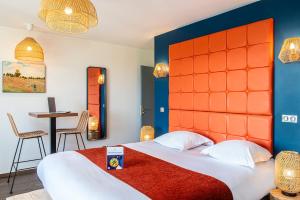 a bedroom with a large bed with an orange headboard at Le Green des Impressionnistes - Cergy-Pontoise in Pontoise