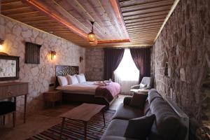 une chambre d'hôtel avec un lit et un canapé dans l'établissement Stone Owl Otel & Restaurant, à Uçhisar