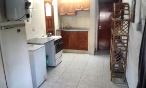 a kitchen with a white stove and a refrigerator at Cabaña frente al Río in Necochea