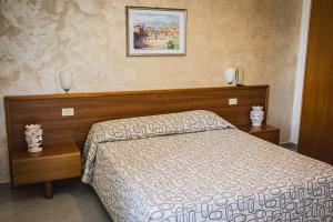 a bedroom with a bed and a picture on the wall at Hotel Alexander in Giardini Naxos +41 photos