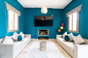 Sala de estar azul con 2 sofás y chimenea en VILLA EDEN Marrakech RESIDENCE APPLE GARDEN 2000m2, en Marrakech