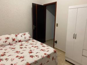 a bedroom with a bed with a flowered comforter at Casa em Jaú capital do calçado feminino Unoeste e Hospital Amaral Carvalho in Jaú