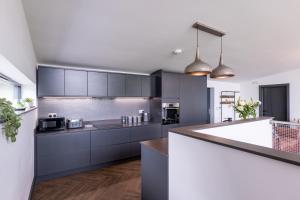 a kitchen with black and white cabinets and a counter at Deer Vue in Exeter