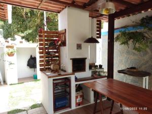a kitchen with a wooden table and a fireplace at Casa Bananeiras Azul in Bananeiras