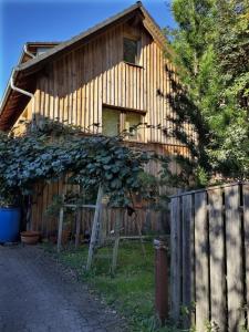 ein Holzhaus mit einem Zaun daneben in der Unterkunft Ferienwohnung Lärchennest 