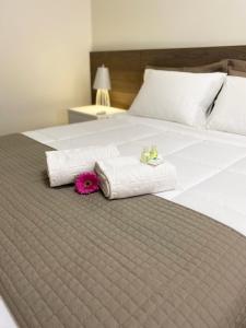 Una cama con dos toallas y dos animales de peluche. en Caitá Hotéis, en Concórdia
