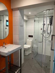 a bathroom with a shower and a toilet and a sink at The Iconic Hotel Ari - Jatujak in Bangkok