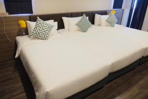 1 cama grande con sábanas y almohadas blancas en The Iconic Hotel Ari - Jatujak en Bangkok