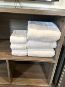 a group of towels are stacked on a shelf at The Iconic Hotel Ari - Jatujak in Bangkok