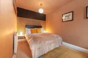 - une chambre avec un grand lit aux murs orange dans l'établissement The Old Naval Laundry - Pure B, à Plymouth