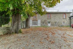 una gran casa de piedra con dos árboles en el patio en Le Charme Antique¶ Belle maison¶ Centre Gières, en Gières