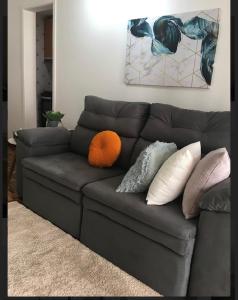 a gray couch with pillows on it in a living room at APTO 2Qtos na Asa Norte in Brasília