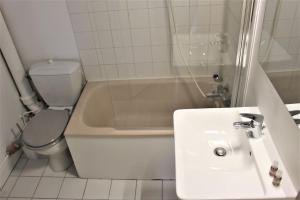 a white bathroom with a sink and a toilet at Charmant studio en centre-ville / proche gare in Le Havre