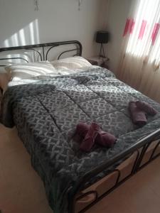 ein Bett mit zwei lila Kissen darauf in der Unterkunft Τα πλατάνια 