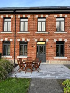 a brick building with a table and chairs in front of it at Superbe Gite de 15 personnes à Taillette in Rocroi