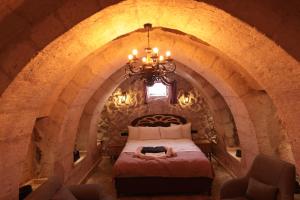 a bedroom with a bed with a woman laying on it at Stone Owl Otel & Restaurant in Uçhisar