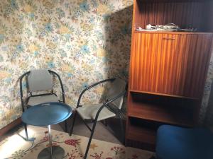 um quarto com 2 cadeiras e um armário de madeira em Avre de Paix au pied des Vignes em Thauvenay