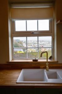 a kitchen sink and a window with a view at The Malt House Artists' Residence in Newlyn