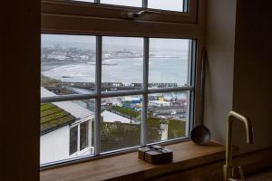 a window in a kitchen with a view of the ocean at The Malt House Artists' Residence in Newlyn