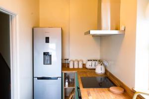 a kitchen with a refrigerator and a wooden counter top at The Malt House Artists' Residence in Newlyn
