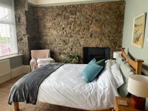 a bedroom with a bed and a stone wall at The Malt House Artists' Residence in Newlyn