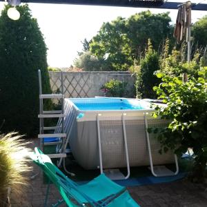 - une piscine avec une échelle et 2 chaises longues à côté dans l'établissement Villa Anna, à Sérignan-du-Comtat